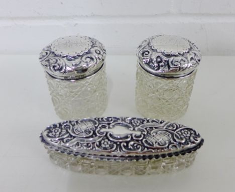 A pair of late Victorian silver topped and cut glass jars together with an oval trinket jar with silver top (3) 