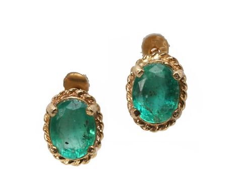 A pair of emerald stud earrings, each with an oval cut emerald, 5mm x 4mm, claw set to a wire twist surround, with post and b