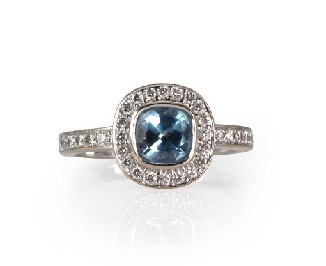 An 18ct white gold aquamarine ring,  with a cushion cut aquamarine, approximately 6mm x 6mm, bezel set to a surround of round