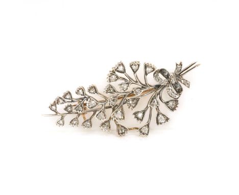 An early 20th century spray brooch, with scattered old cut, rose cut and eight cut diamonds, faced in white and grain set to 