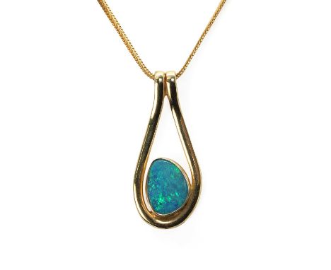 A free form opal pendant and chain, the pendant featuring a free form black opal bezel set to a closed back collet within a d