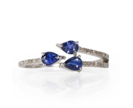 A silver sapphire and diamond open trident style ring,  with three central pear cut sapphires, all claw set, into three lines