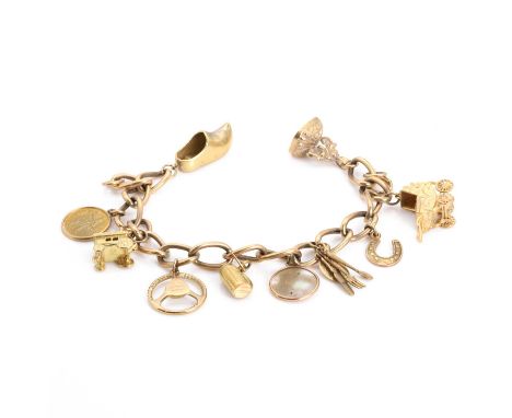 A 9ct gold charm bracelet, a hollow curb link bracelet, to a half solid bolt ring, 190mm long, Birmingham 1962, suspending te