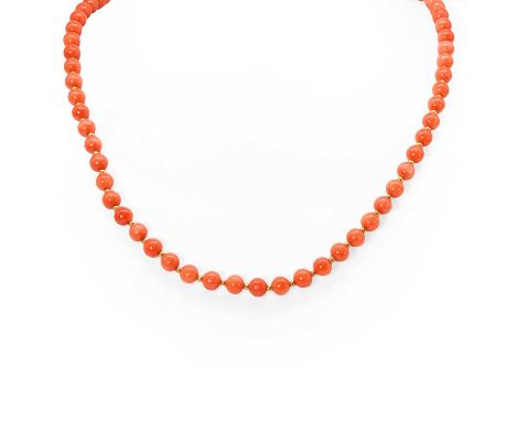 A single row coral bead necklace,  with a series of uniform red coral beads, 5.50 to 6.00mm, interspersed with yellow meal be