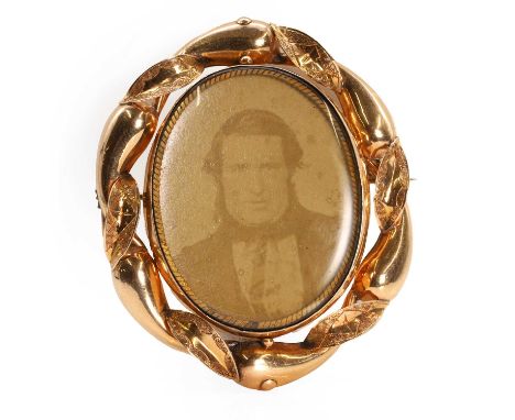 A Victorian swivel locket mourning brooch, with a central oval swivel photo-locket with a glazed panel to both sides, suspend