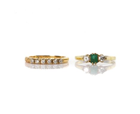 An emerald and diamond ring and a diamond half eternity ring, an 18ct gold emerald and diamond ring,with a central step cut e