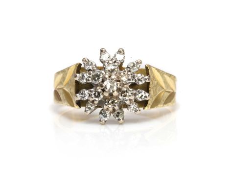 An 18ct gold diamond cluster ring,  a tiered circular cluster of eight cut diamonds, to tapered shoulders with foliate engrav