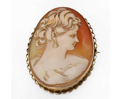 A shell cameo brooch, an oval shell cameo depicting a lady in profile with curled hair and wearing a drop earring, to a scall