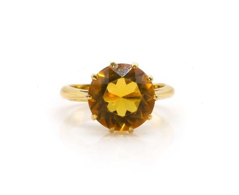 A single stone paste ring, with a round mixed-cut yellow paste, claw set to the centre, to chenier shoulders, and a plain ban