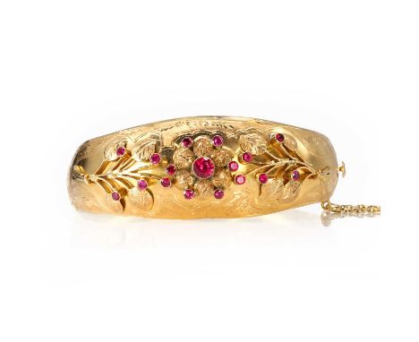 A gold and synthetic ruby floral bangle,  a domed hinged bangle, hinge pin deficient, with floral and foliate panels bezel se