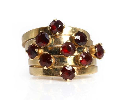 A garnet Harem ring,  five tapered bands with round cut garnets claw set in a kite shape, all gathered and held with a shank 