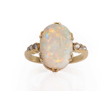 An Edwardian opal and rose cut diamond ring,  with an oval opal cabochon, claw set, to shoulders rub over set with a graduate