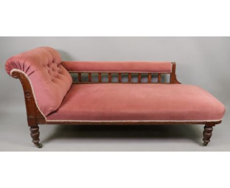 An Edwardian oak frame chaise longue, button down upholstered in pink, on turned legs and castors, 180cm wide x 66cm deep x 8