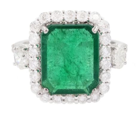 18ct white gold emerald and round brilliant cut diamond cluster ring, with two oval cut diamonds set either side and diamond 