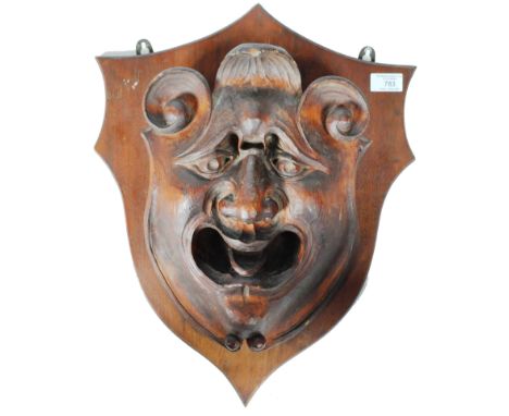 An antique 19th Century Victorian hand carved pine grotesque face mask of good size having ornate scrolled top with detailed 