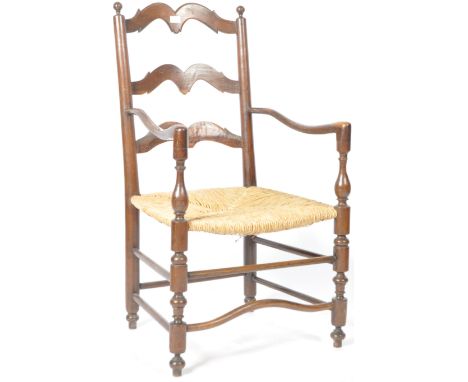 An antique 18th Century Georgian English country house oak farmhouse ladder back carver armchair having a shaped backrest wit