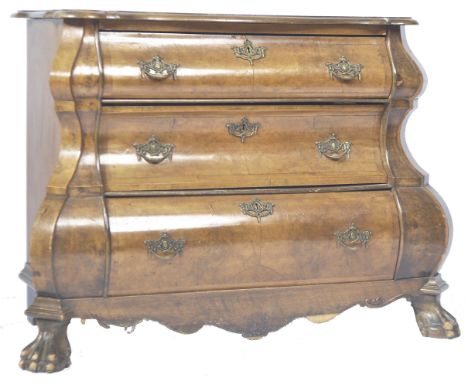 An antique 18th Century Dutch walnut commode chest of drawers of bombe shape having a carved serpentine shaped top raised ove