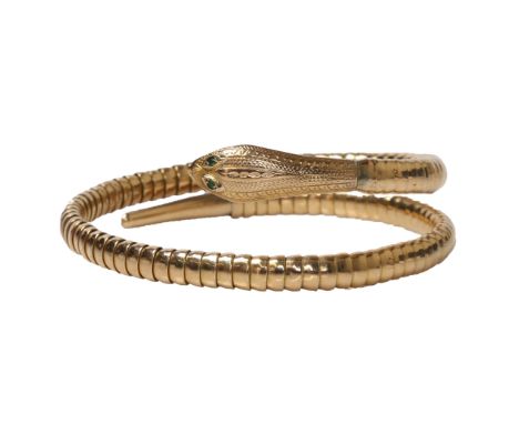 VINTAGE CIRCA 1960 SERPENT BANGLE. An articulated serpent bangle with a pair of green paste set eyes. Head and tail with deco
