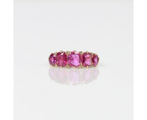 LATE VICTORIAN RUBY FIVE STONE RING. Five graduated cushion mixed cut rubies, principle measures 6.9 x 5.6mm. Smallest ruby m