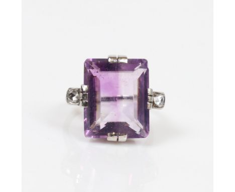A VINTAGE AMETHYST AND DIAMOND COCKTAIL RING. One rectangular step cut amethyst approx. 10.80ct. Flanked with one rose cut di