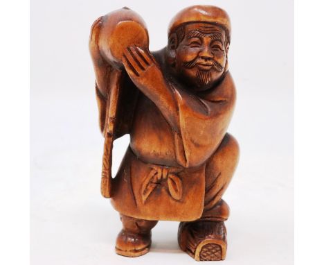 Japanese carved wood netsuke, in the form of a worker carrying a barrel, bearing signature, H: 40 mm. UK P&amp;P Group 1 (£16