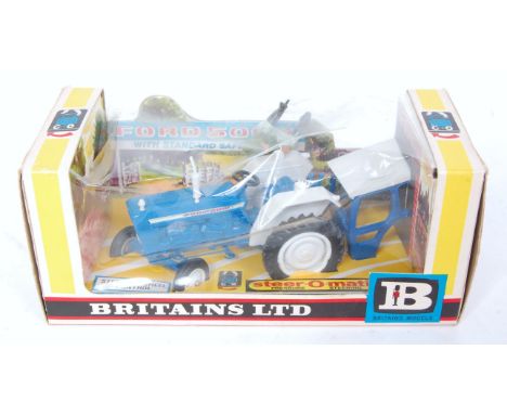A Britains No. 9527 Ford 5000 tractor with standard safety cab comprising blue body with white hubs and driver figure, housed