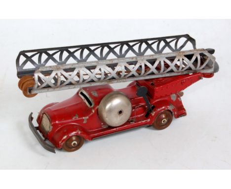 An early pre-war German tinplate and clockwork turntable fire engine comprising red body with bronzed hubs, working bell, and