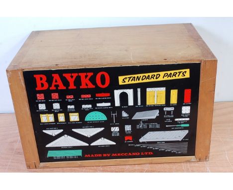 A Bayko 1960s Meccano Era 3-drawer wooden retailer's cabinet, with original black ground card, containing a quantity of vario