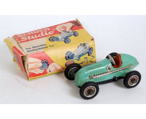 A Schuco Studio tinplate and clockwork race car comprising of light green body with black base and racing No. 4 housed in the
