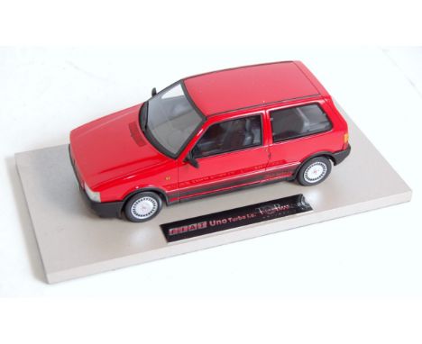 A BBR Models Top Marques Collection 1/18 scale model of a Fiat Uno Turbo finished in red with grey and red interior, housed i