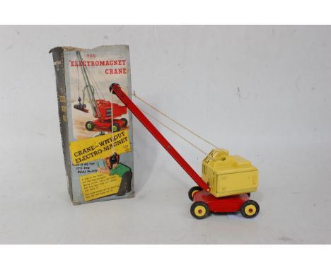 A DCMT No. 121 4-wheel Electro Magnetic Crane comprising of red and yellow body with yellow hubs and red boom arm, sold in th