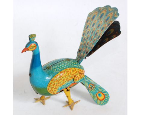An Alps of Japan tinplate and clockwork model of a walking peacock, comprising of blue, green and yellow tinprinted body with