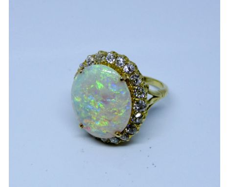 Large and impressive opal and diamond cluster ring set with a large oval opal  surrounded by brilliant cut diamonds on an 18c