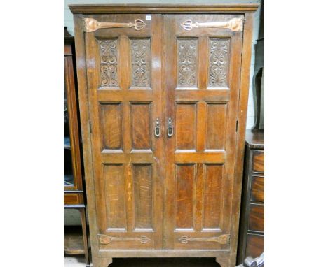 Arts and Crafts style oak two door wardrobe with stick stand mirror etc inside door, fitted two doors with carved wood panels