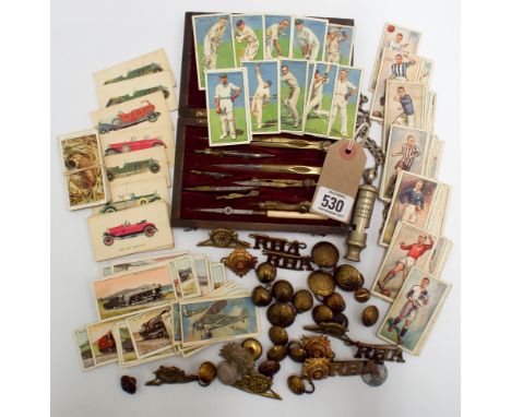 Small collection of cigarette cards, police whistle, military buttons, insignia, and a drawing set contained with a mahogany 