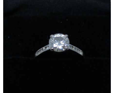 Solitaire diamond ring set with a claw set circular brilliant cut diamond with diamond set shoulders, 18ct white gold shank, 