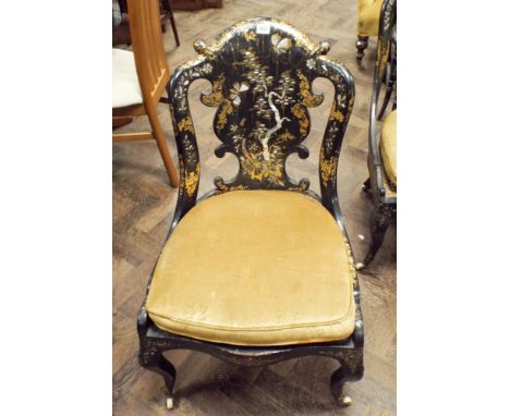 A Victorian black lacquered gilt and mother of pearl decorated occasional chair with cane panelled seat standing on cabriole 