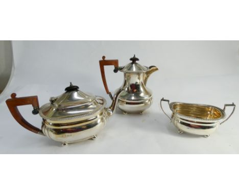 Three piece hallmarked silver tea service comprising tea pot, hot water jug and twin handled sugar basin. Modern Birmingham h
