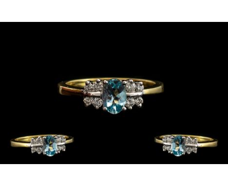 18ct Gold - Attractive Aquamarine and Diamond Set Dress Ring. Full Hallmark for 750 - 18ct. The Central Aquamarine Flanked by