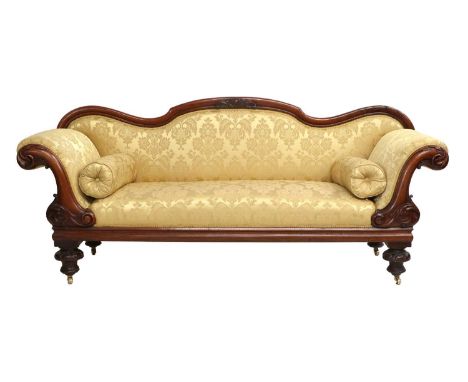 A Victorian Carved Mahogany Sofa, circa 1870, recovered in yellow and gold silk damask, with scrolled and carved arm supports