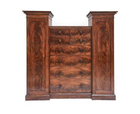 A Victorian Flame Mahogany Inverted Breakfront Wardrobe. 3rd quarter 19th century, the wings with moulded pediments above arc