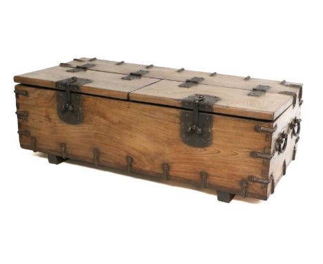 A Japanese Hardwood and Iron-Bound Trunk, modern, used as a coffee table with later glass top, the hinged lid with metal clas