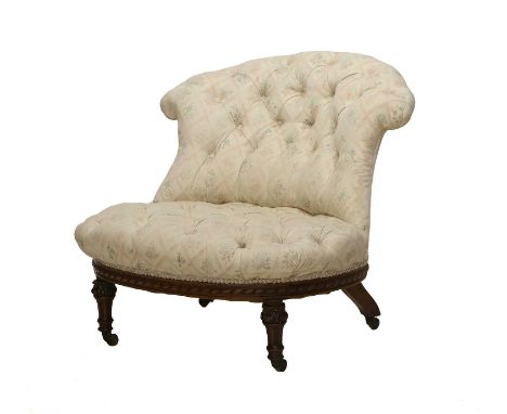 Holland &amp; Sons: A Victorian Carved Walnut Nursing Chair, late 19th century, recovered in cream, floral and buttoned fabri