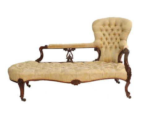 A Victorian Carved Rosewood Framed Sofa, circa 1870, recovered in yellow and cream floral buttoned silk damask, the padded ba