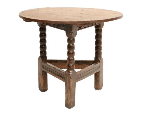 A Circular Oak Cricket Table, late 17th/early 18th century, of plank-top construction with carved frieze, on bobbin-turned le