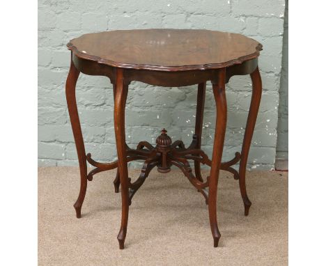 An Edwardian mahogany window table with shaped supports and central turned finial to stretcher.