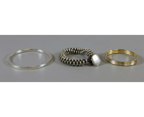 A silver shoe lace bracelet, silver bangle and an Italian silver and silver gilt bracelet.