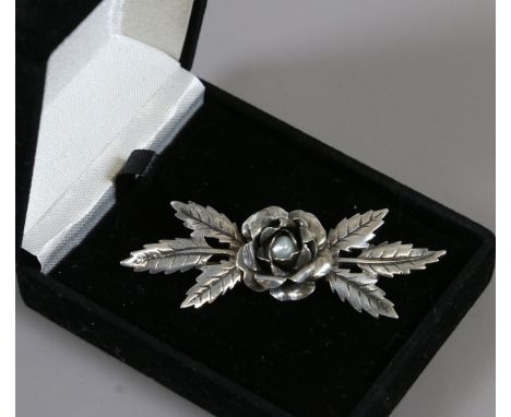 A sterling silver flower spray brooch set with a seed pearl.