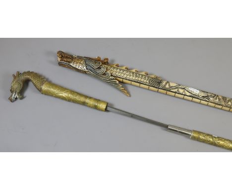 An oriental brass sword stick with floral decoration and serpent handle, along with a composite oriental blow pipe decorated 