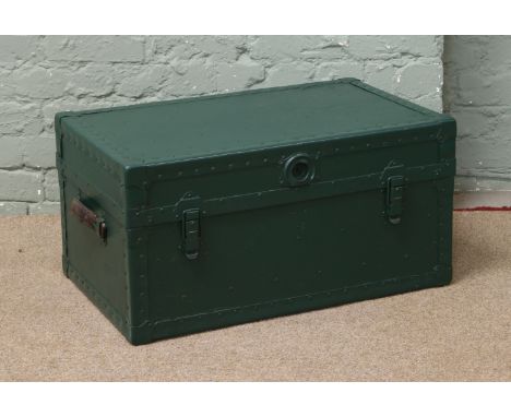 A painted metal bound travel trunk with leather carry handles.